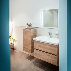 Ein modernes Badezimmer mit einem eleganten Holzwaschtisch und einem großen Spiegel, der den Raum hell erleuchtet.