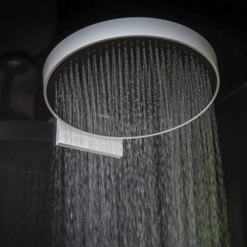 Eine moderne, runde Regendusche mit gleichmäßig fließendem Wasser, das sanft nach unten strömt.