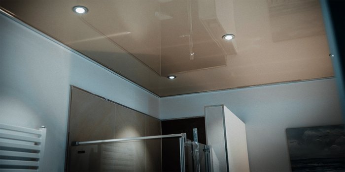 Die Decke eines modernen Badezimmers mit glänzender Oberfläche und integrierten LED-Lichtern, die eine helle Atmosphäre schaffen.