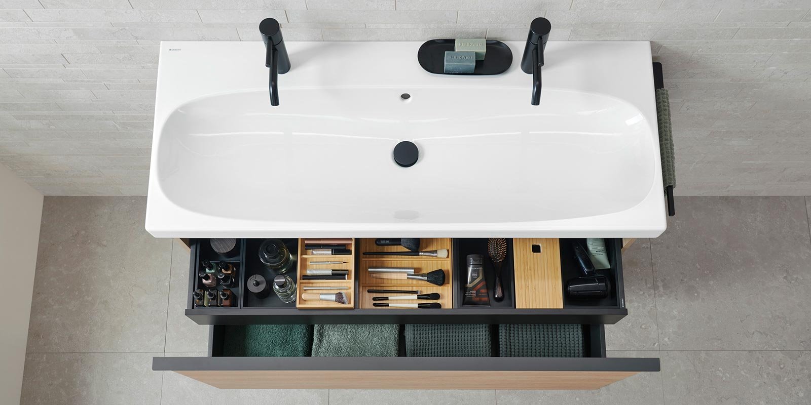 Die Badewanne ist mit zwei schwarzen Wasserhähnen ausgestattet, während der Unterbau praktische Aufbewahrung bietet.