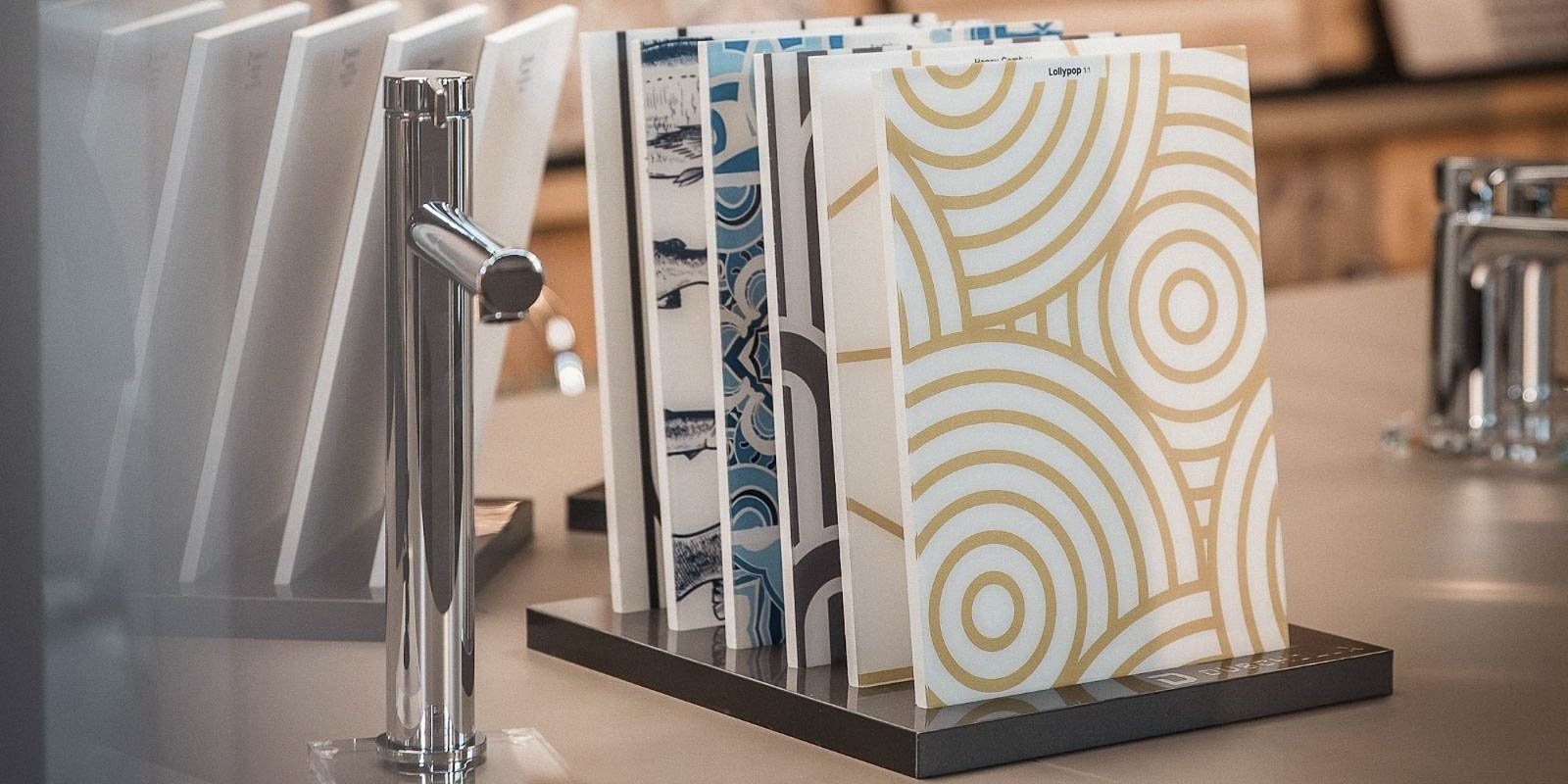 Eine stilvolle Präsentation von Musterheften mit geometrischen Designs, die auf einem eleganten Tisch angeordnet sind.