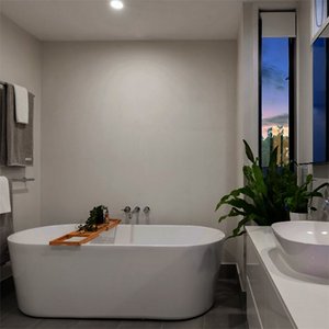 Ein modernes Badezimmer mit einer freistehenden Badewanne, die mit einem Holzbrett dekoriert ist, und einem großen Fenster.