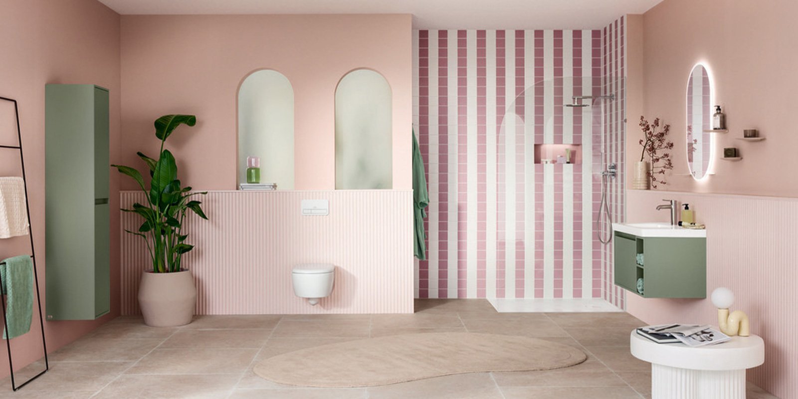 Ein modernes Badezimmer mit sanften rosa Wänden, einer eleganten Dusche und einer stilvollen grünen Waschtischkombination.