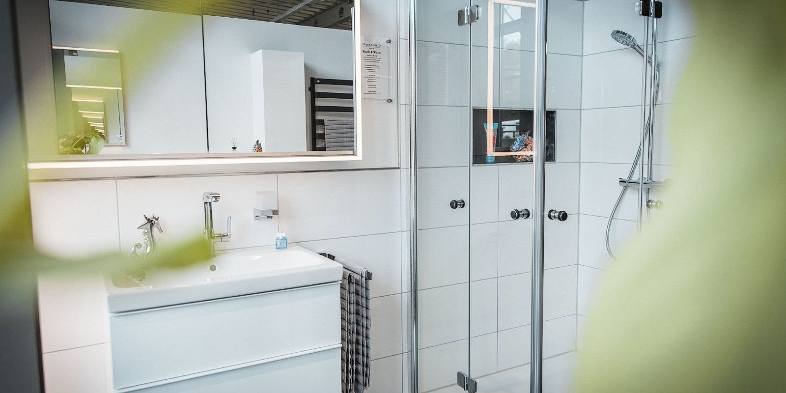 Ein modernes Badezimmer mit einem eleganten Waschbecken und einem großen Spiegel, der die Umgebung reflektiert.