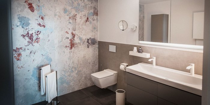 Ein modernes Badezimmer mit einer stilvollen Wandgestaltung in sanften Farben und eleganten Armaturen.