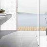Ein modernes Badezimmer mit einem eleganten Waschbecken aus Beton und Blick auf einen ruhigen See durch große Fenster.